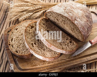 Sliced black bread on the old wooden plank. Stock Photo