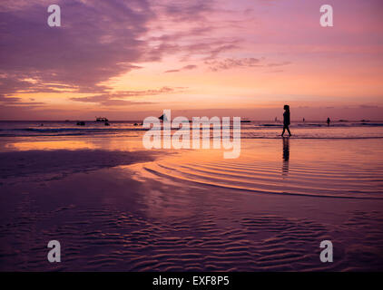 Silhouetted young woman on beach at sunset, Boracay Island, Visayas, Philippines Stock Photo