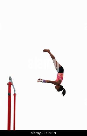 Young gymnast performing on uneven bars Stock Photo