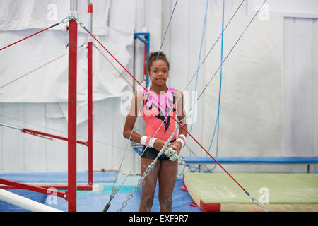 Portrait of young gymnast, standing by gymnastic equipment Stock Photo