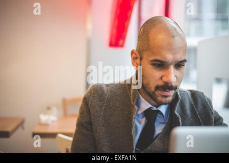 Businessman sitting in cafe using laptop Stock Photo
