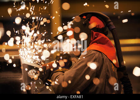 Sparks and worker using grinder Stock Photo