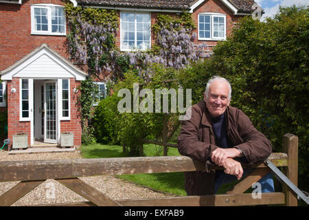 Senior man, leaning on garden fence Stock Photo