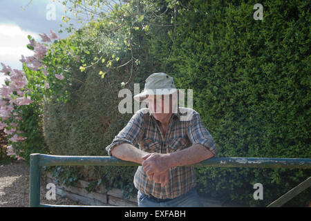 Senior man, leaning on garden fence Stock Photo