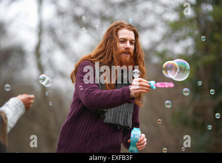 Man blowing soap bubbles in countryside Stock Photo