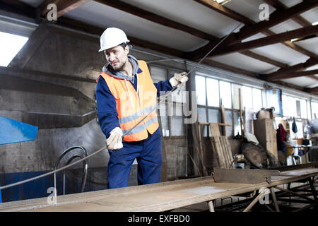 Factory worker moving steel rod at concrete reinforcement factory Stock Photo