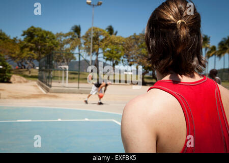 Two young men playing basketball on basketball court Stock Photo