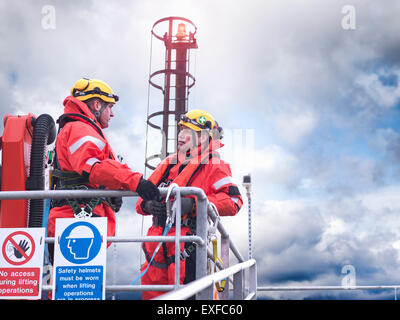 Offshore windfarm workers in discussion on jetty at sea
