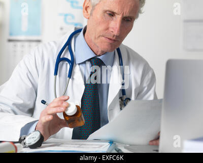 Doctor checking medical notes before prescribing drugs Stock Photo