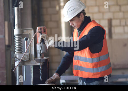 Factory worker using drill in concrete reinforcement factory Stock Photo