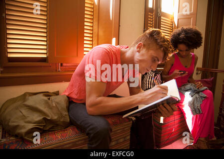 Students chilling out and studying in living room Stock Photo