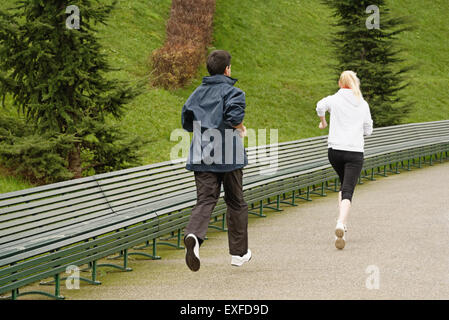 Man and woman running along pathway, rear view Stock Photo