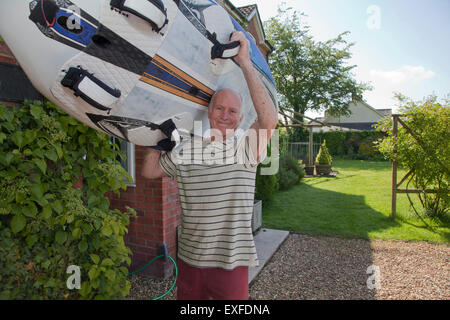 Senior man carrying surfboard Stock Photo
