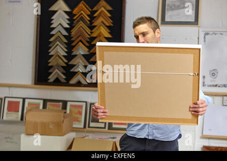 Man inspecting frame in picture framers workshop Stock Photo