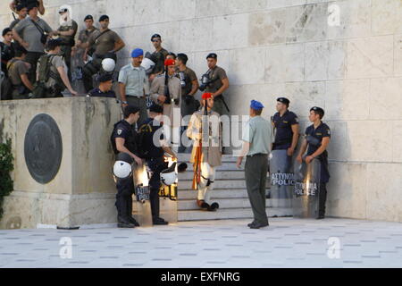 Athens, Greece. 13th July 2015. The Evzones (Greek Presidential Guards) return to Syntagma Square through a row of riot police officers. They had retreated earlier on during the protest. Greeks assembled outside the Greek Parliament under the banner of 'We leave this Europe'. They called for the government to not give into the demands of the Greek creditors for more austerity measures, but rather to leave the Eurozone. Credit:  Michael Debets/Alamy Live News Stock Photo