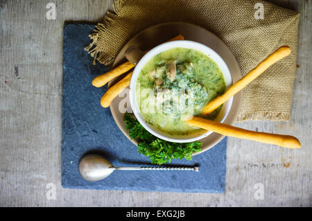 Chicken soup with bread sticks on the rustic kitchen Stock Photo