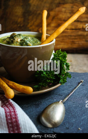 Chicken soup with bread sticks on the rustic kitchen Stock Photo