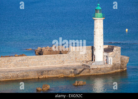 White lighthouse tower with green top. Entrance to Propriano port, Corsica, France Stock Photo