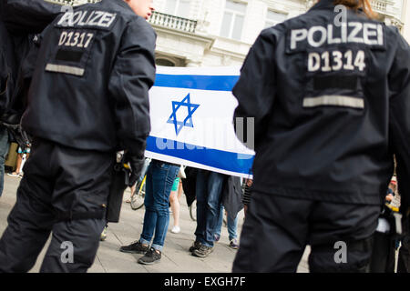 Berlin, Germany. 11th July, 2015. Pro-Israeli demonstrators hold an Israeli flag as participants of a Pro-Palestinian rally march past them in Berlin, Germany, 11 July 2015. Anti-Israeli rallies are held in Iran on Quds Day. Photo: GREGOR FISCHER/dpa/Alamy Live News Stock Photo
