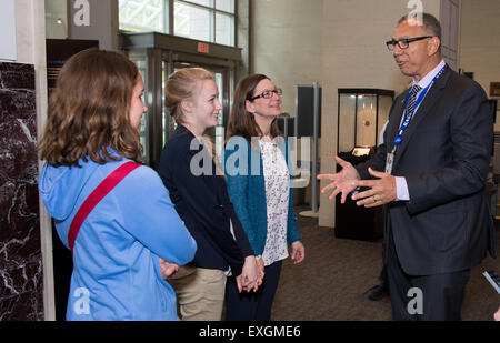 Donald James, associate administrator for Education at NASA, congratulates Makayla Stewart, a student from Nicholson Elementary School in Picayune, Miss., left; Anna Lander, a student at Picayune Memorial High School who assisted Nicholson Elementary's team, center; and Maureen Pollitz, a teacher from Nicholson Elementary School who led her team to become finalists in the Samsung &quot;Solve for Tomorrow&quot; contest, winning a $120,000 award, on Tuesday, April 28, 2015 at NASA Headquarters in Washington. They built a prototype robot that investigates city drainage systems to identify problem Stock Photo