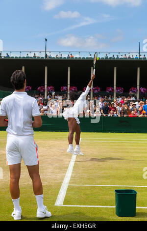 Serena Williams warms up her serve on Court No. 5, watched by coach Patrick Mouratoglou, during the Wimbledon Championships 2015 Stock Photo