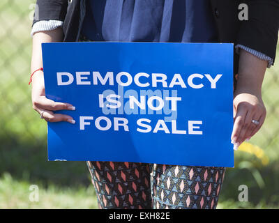 Waukesha, Wisconsin, USA. 13th July, 2015. A woman holds a protest sign in front of the Waukesha Convention Center in Waukesha, Wisconsin where Governor Scott Walker is about to make an annoucement that he will run for President in the 2016 United States Presidential election. Credit:  Julia Hansen/Alamy Live News Stock Photo