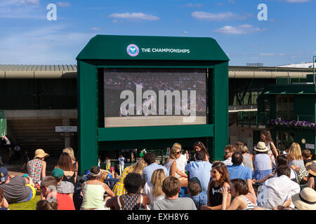 Spectators watch a tennis match on screens from the Hill at Aorangi Terrace, also known as Henman Hill, during Wimbledon 2015 Stock Photo