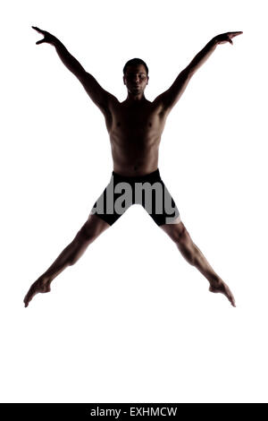 Silhouette of an muscular adult male modern contemporary ballet style dancer. Dancer is wearing black ski pants and is isolated  Stock Photo