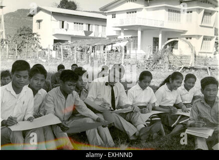 Roderick MacRae, a volunteer, contributed his services at the Pakse Teachers College in Laos. His work focused on educational support, including teaching drawing and art classes to students. This image captures a classroom scene with a teacher guiding children in an artistic activity, highlighting the volunteer work in educational development in Laos. Stock Photo