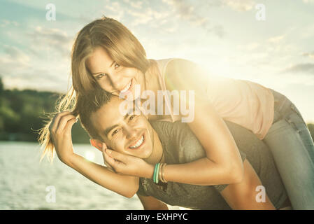 Couple in love embracing at the lake, sun flare Stock Photo