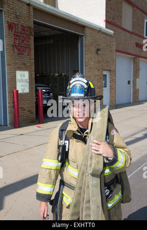 Female firefighter in rural volunteer fire department working with equipment. Stock Photo