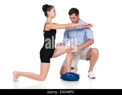 Adult male physiotherapist is assisting a female patient in rehabilitation exercises. Stock Photo