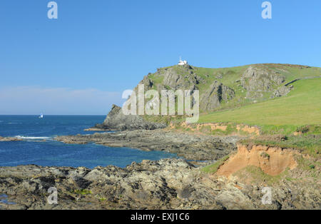 View Across Rocks to East Prawle Lighthouse on the South West Coastal Path, near Salcombe, on the South Devon Coast, England, UK Stock Photo