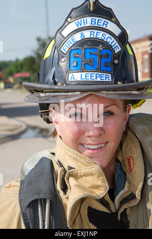 Female firefighter in rural volunteer fire department working with equipment. Stock Photo