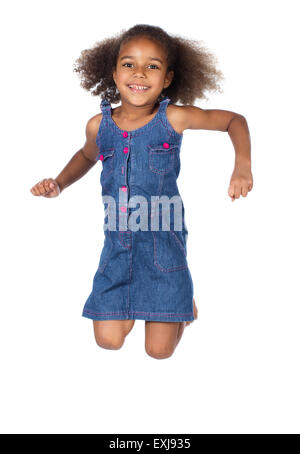 Adorable cute african child with afro hair wearing a denim dress. The girl is jumping and smiling. Stock Photo