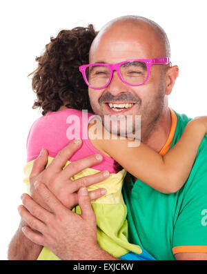 Adorable small caucasian child with curly hair wearing a pink blue and yellow dress. The girl and her father are playing with pi Stock Photo