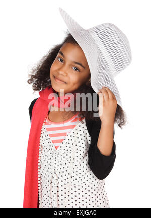 Adorable cute African child with afro hair is playing dress up. She is wearing a white dress with dots, a hat, scarf and high he Stock Photo