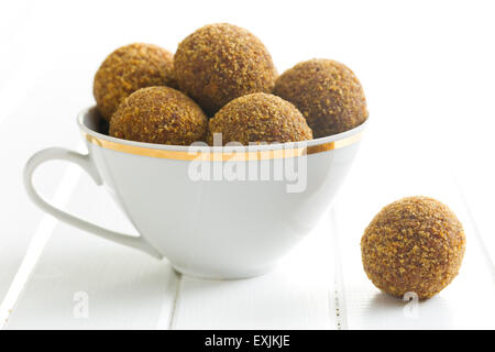 sweet truffles in mug on kitchen table Stock Photo