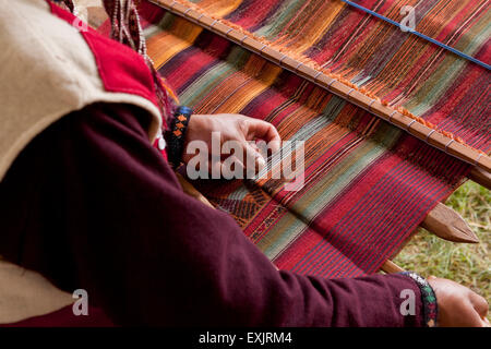 Peruvian man from Chinchero weaving traditional fabric using back strap loom Stock Photo