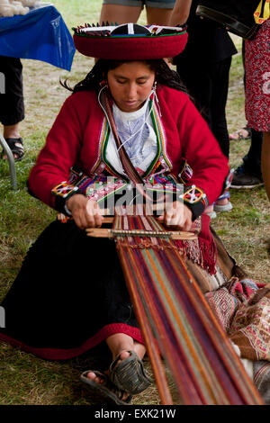 Peruvian woman from Chinchero weaving traditional fabric using a back strap loom Stock Photo