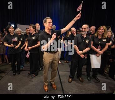 Laurel, Maryland, USA. 14th July, 2015. Johns Hopkins University APL Director Ralph Semmel waves an American flag and praises the hard work of all that worked New Horizons spacecraft after the space probe flyby of Pluto at Johns Hopkins University Applied Physics Laboratory July 14, 2015 in Laurel, Maryland.