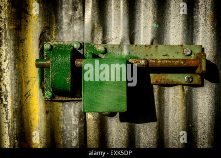 Green rusty padlock on colorful garage door. Stock Photo