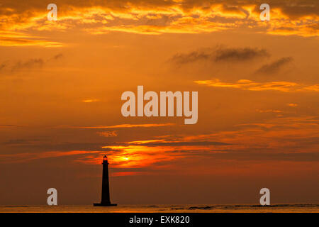 Sunrise over Morris Island Light house seen from Folly Beach July 13, 2015 in Folly Beach, SC. Morris Lighthouse dates back to 1767 and the land around it slowly eroded until it now sits completely surrounded by water. Stock Photo