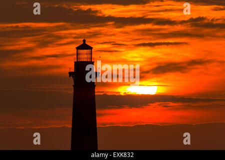 Sunrise over Morris Island Light house seen from Folly Beach July 13, 2015 in Folly Beach, SC. Morris Lighthouse dates back to 1767 and the land around it slowly eroded until it now sits completely surrounded by water. Stock Photo