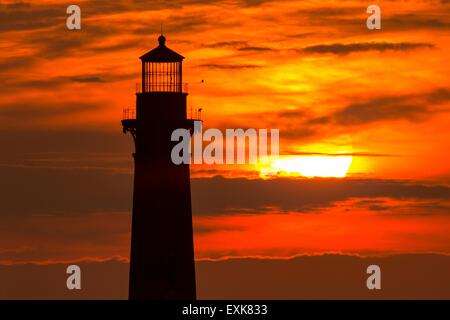 Sunrise over Morris Island Light house seen from Folly Beach July 13, 2015 in Folly Beach, SC. Morris Lighthouse dates back to 1767 and the land around it slowly eroded until it now sits completely surrounded by water. Stock Photo