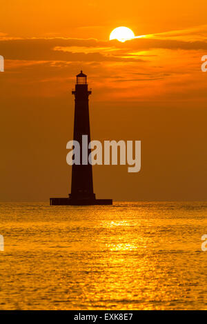 Sunrise over Morris Island Light house seen from Folly Beach July 13, 2015 in Folly Beach, SC. Morris Lighthouse dates back to 1767 and the land around it slowly eroded until it now sits completely surrounded by water. Stock Photo