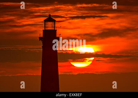 Sunrise over Morris Island Light house seen from Folly Beach July 13, 2015 in Folly Beach, SC. Morris Lighthouse dates back to 1767 and the land around it slowly eroded until it now sits completely surrounded by water. Stock Photo