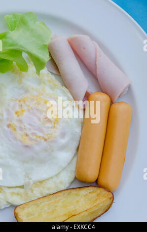 fried egg , ham , sausage and grilled potato on dish , fresh breakfast Stock Photo