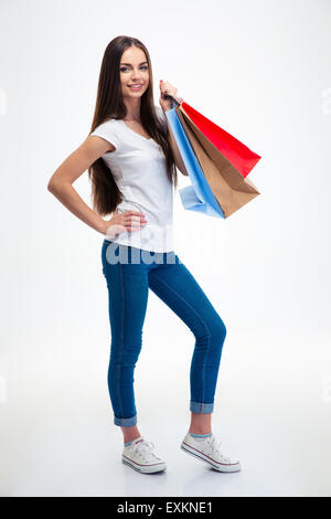 Full length portrait of a smiling attractive woman holding shopping bags isolated on a white background Stock Photo
