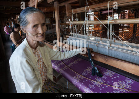 Old local woman weaving fabric from lotus flower silk, lotus weaving, Paw Khone, Inle lake, Shan State, Myanmar Stock Photo